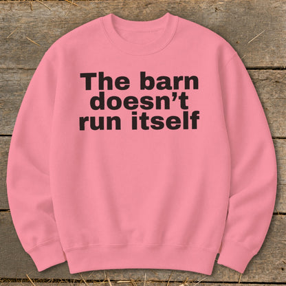 Pink sweatshirt with black text that reads "The barn doesn't run itself".