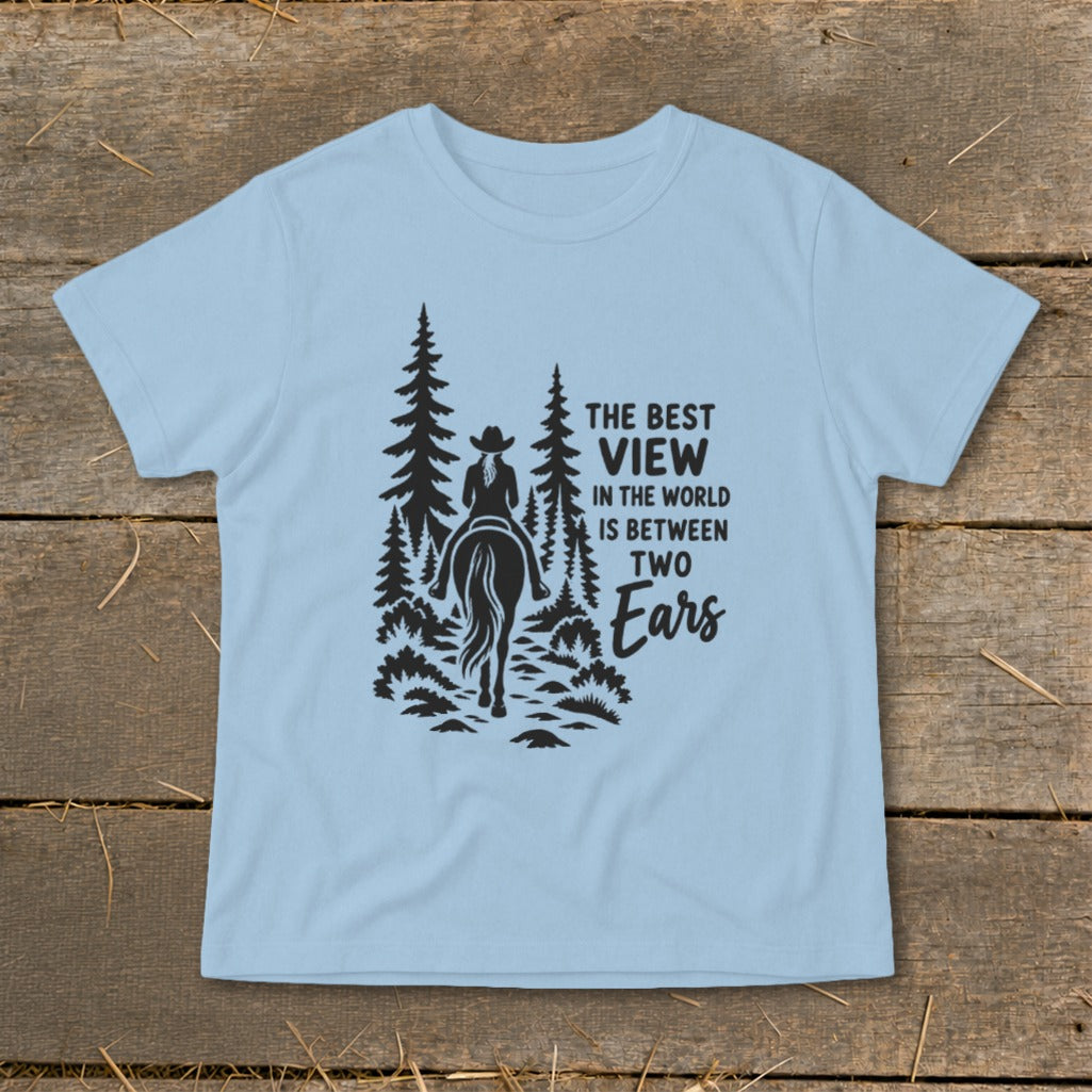 Light blue t-shirt featuring a black silhouette of a horseback rider and text reading The Best View in the World Is Between Two Ears.