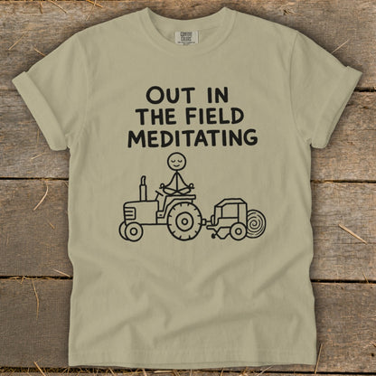 T-shirt with "Out in the Field Meditating" text and a stick figure meditating on a tractor.