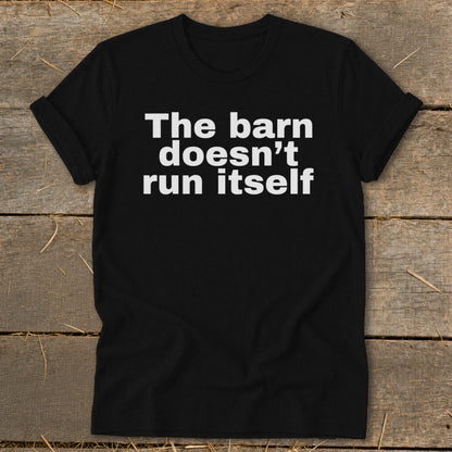 Black t-shirt with white text that reads "The barn doesn't run itself."