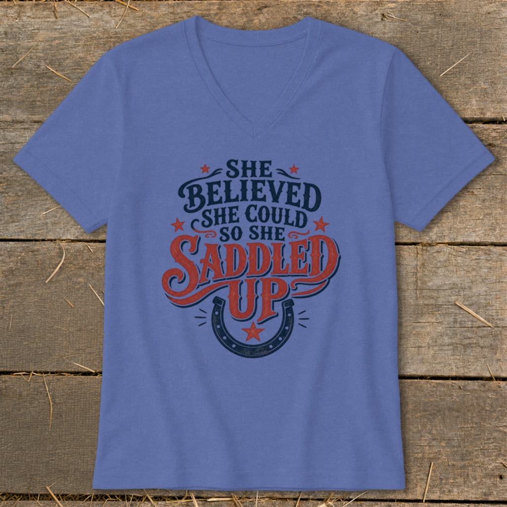 Purple v-neck t-shirt with "She believed she could so she saddled up" text and horseshoe.