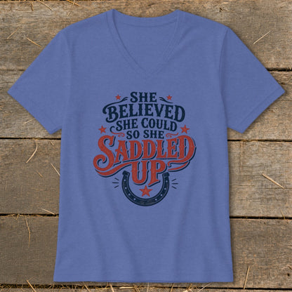 Purple v-neck t-shirt with "She believed she could so she saddled up" text and horseshoe.