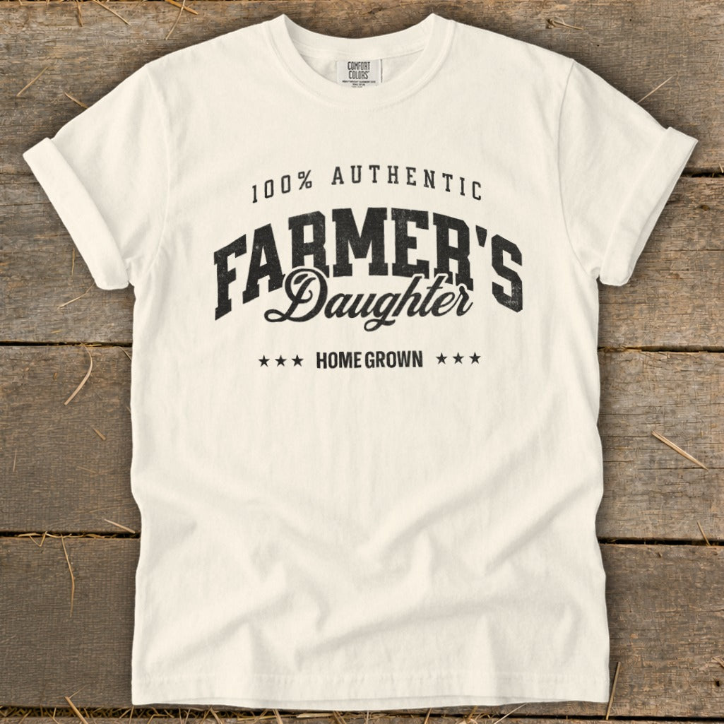 Cream t-shirt with black text that reads "100% Authentic Farmer's Daughter Home Grown".