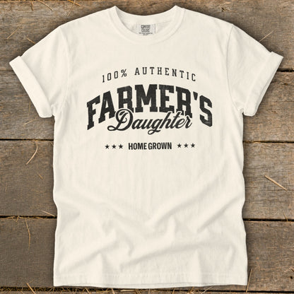 Cream t-shirt with black text that reads "100% Authentic Farmer's Daughter Home Grown".
