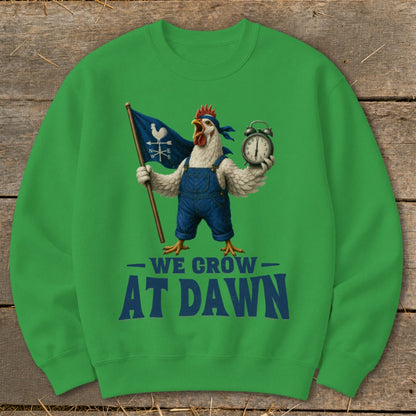 Green sweatshirt with chicken in overalls holding a flag and alarm clock, text reads "We Grow At Dawn."