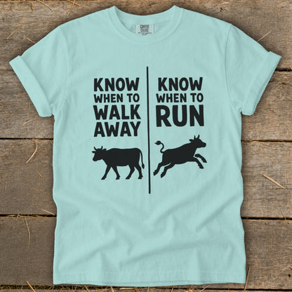 Light blue t-shirt with "Know When To Walk Away" and "Know When To Run" text and cow illustrations.