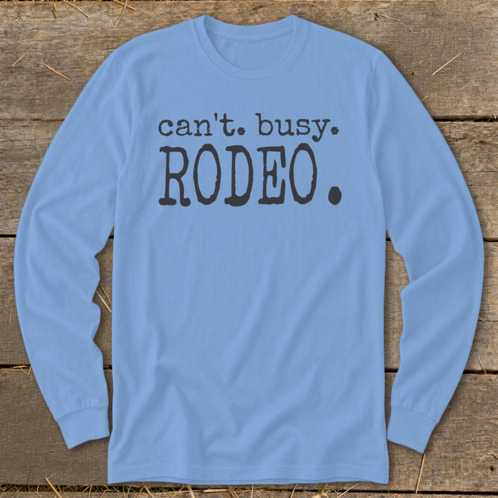 Light blue long sleeve shirt with "can't. busy. RODEO." printed on it.