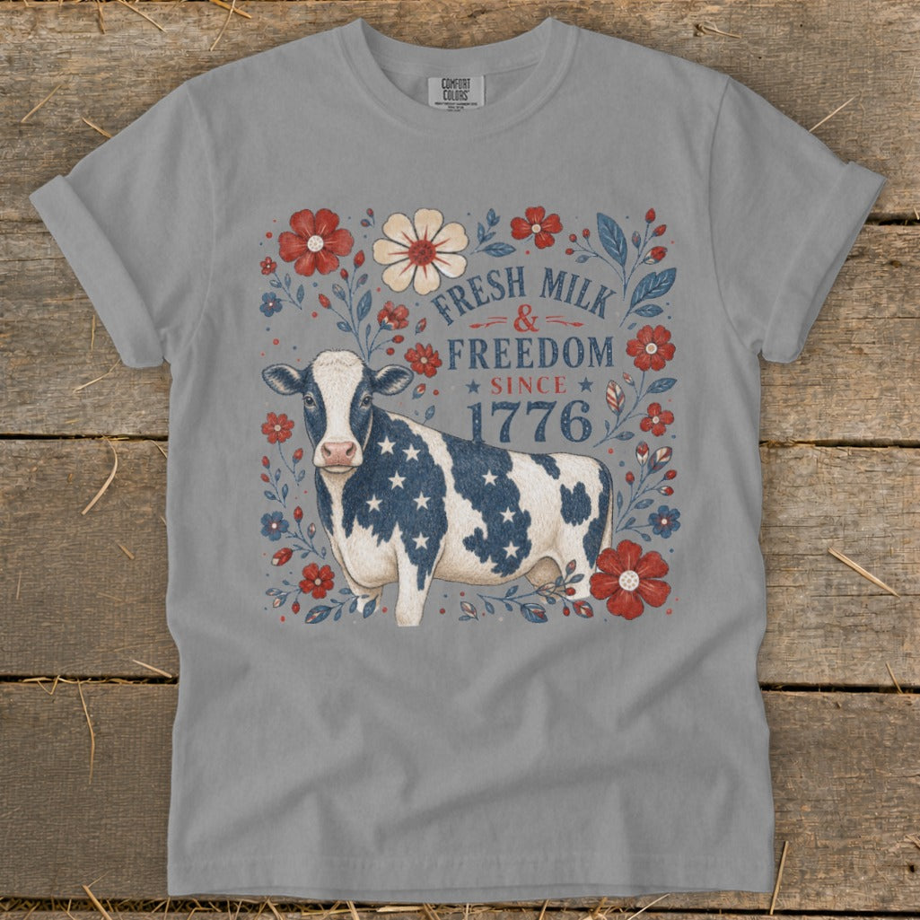 Cow with American flag pattern surrounded by flowers, text reads "Fresh Milk & Freedom Since 1776".