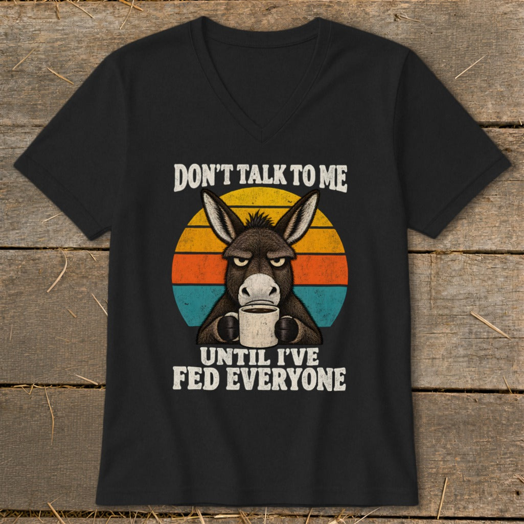 Black V-neck t-shirt featuring a graphic of a grumpy donkey holding a coffee mug and text.