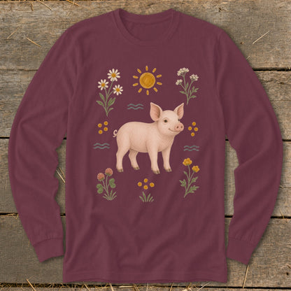 Burgundy long-sleeve shirt with a smiling pig surrounded by flowers and sun.