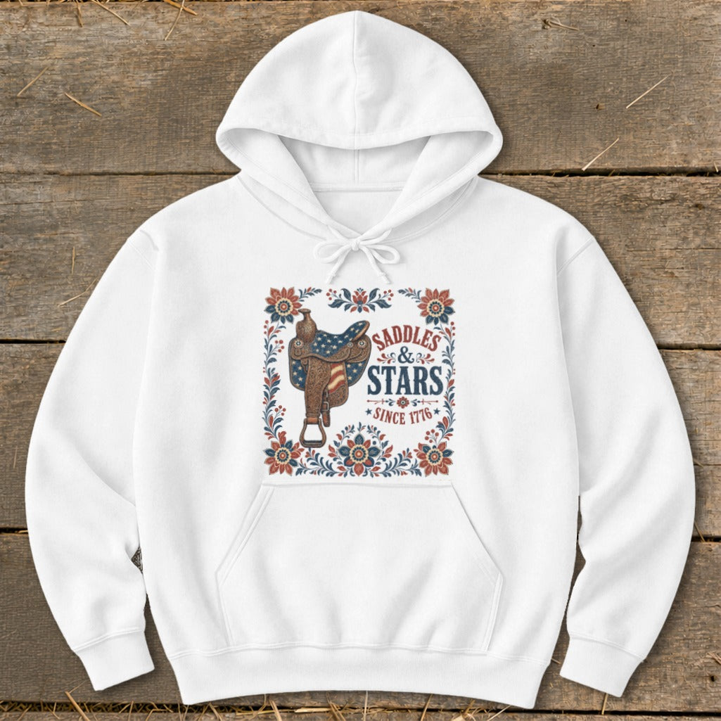 White hoodie with "Saddles & Stars Since 1776" graphic featuring a saddle and American flag design.
