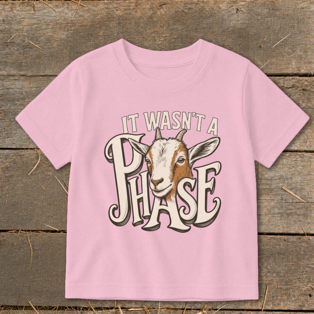Pink t-shirt with a goat graphic and text "IT WASN'T A PHASE".