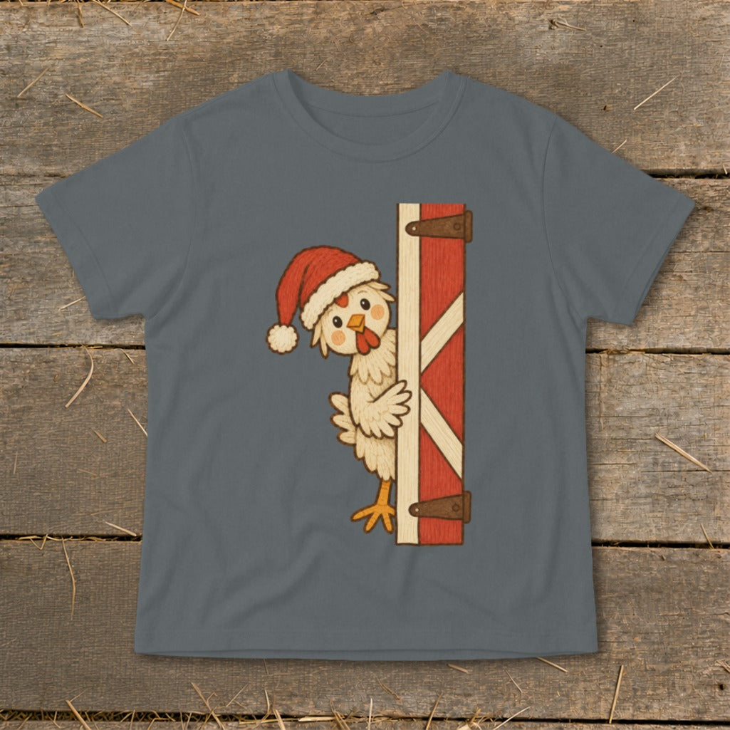 Christmas chicken peeking from behind a red barn door on a grey t-shirt.