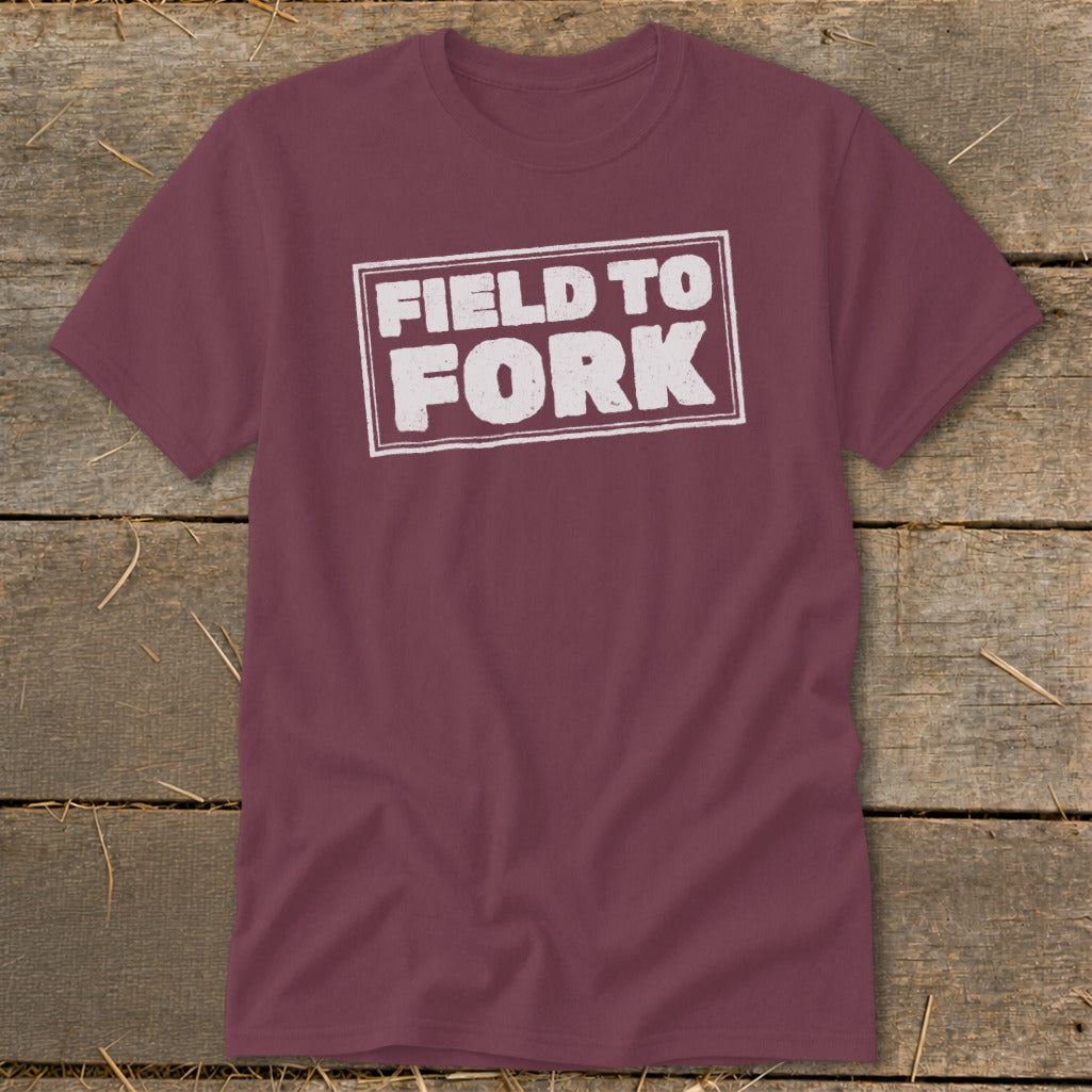 A maroon crewneck short-sleeve t-shirt with the white distressed text "FIELD TO FORK" inside a rectangular border.