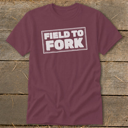 A maroon crewneck short-sleeve t-shirt with the white distressed text "FIELD TO FORK" inside a rectangular border.