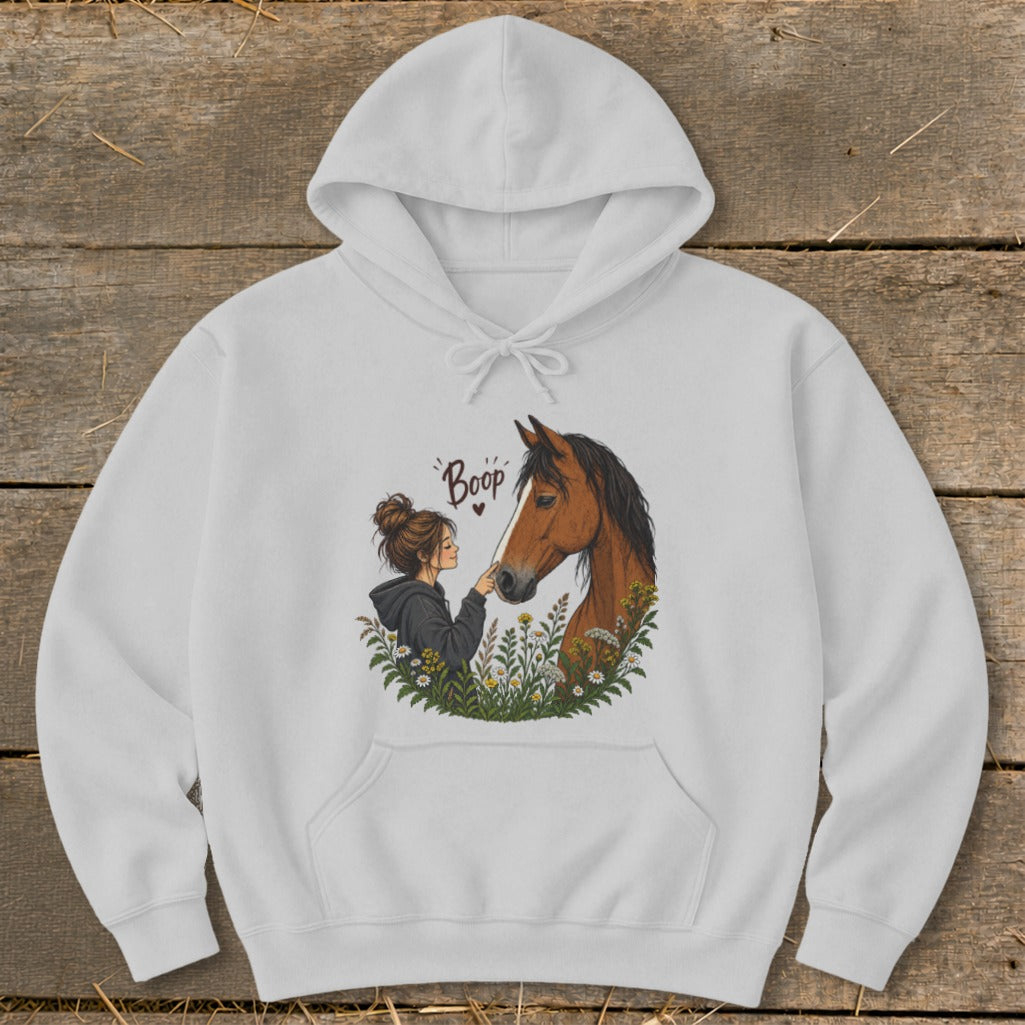 Illustration of a girl booping a horse's nose in a field of flowers.