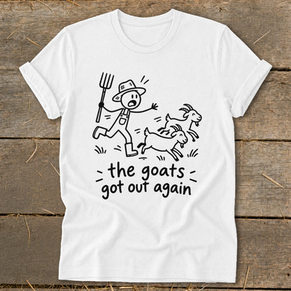 White t-shirt with stick figure farmer chasing three goats, text "the goats got out again".