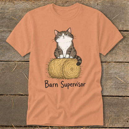 Cat sitting on hay bale with "Barn Supervisor" text on orange t-shirt.