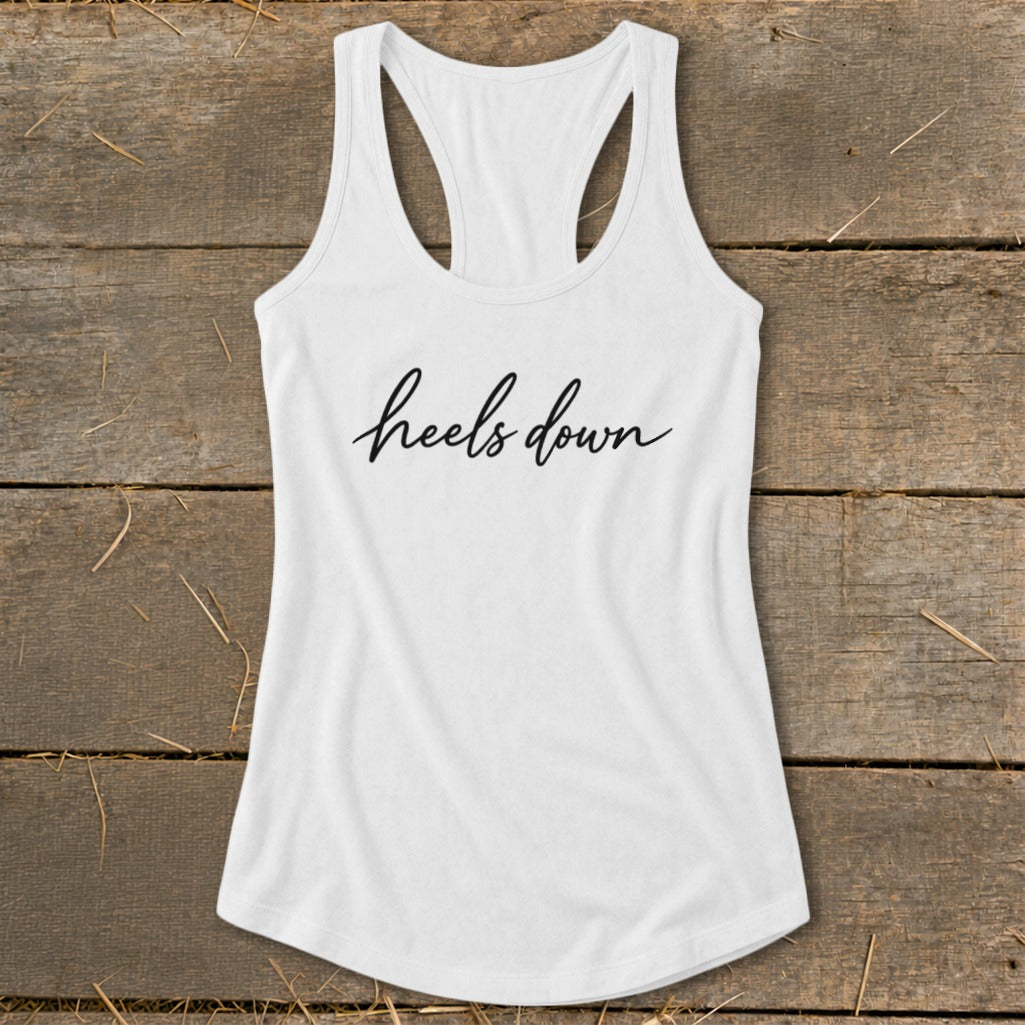 White racerback tank top with "heels down" written in black script.