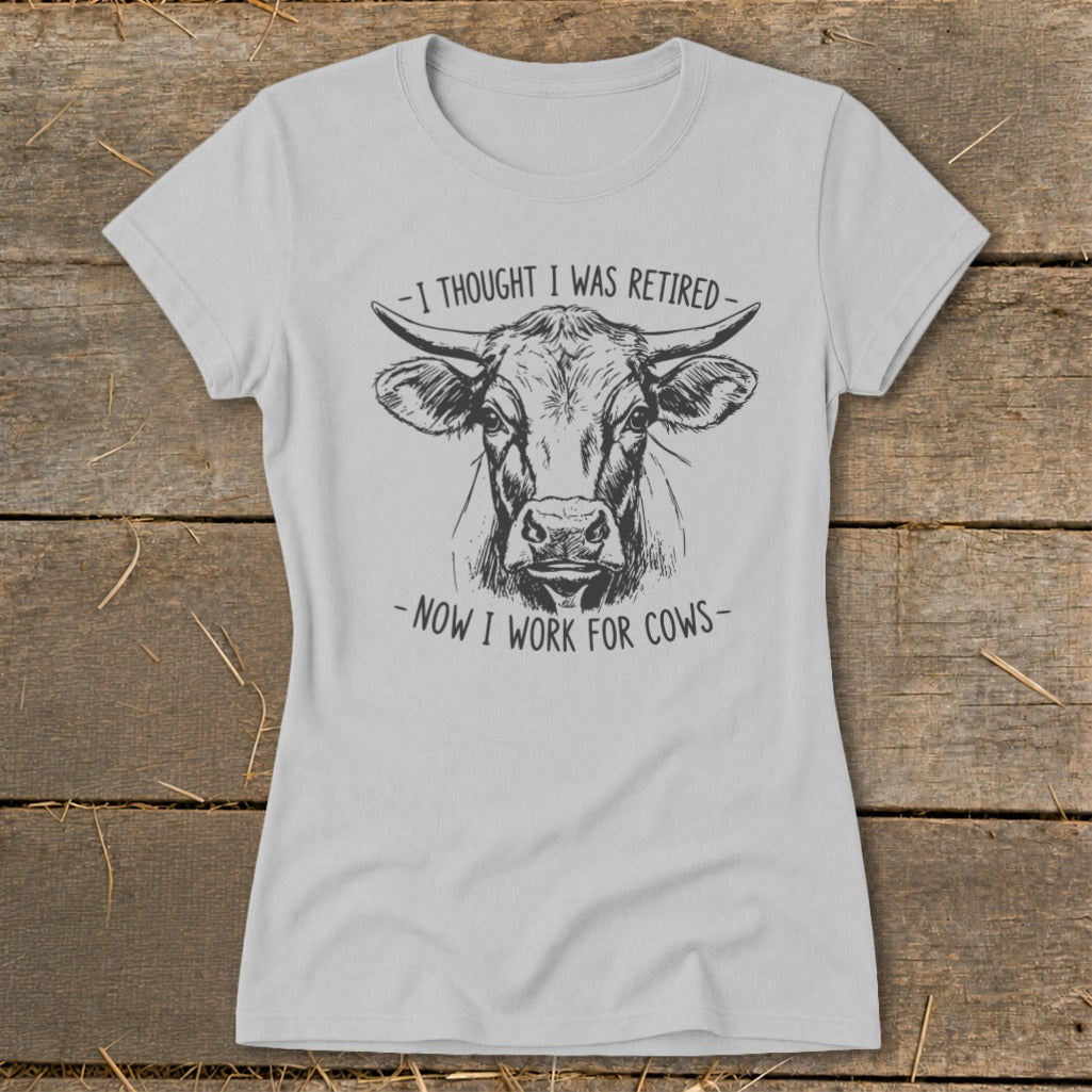 Light gray t-shirt with a sketch of a cow and text "I thought I was retired - Now I work for cows".