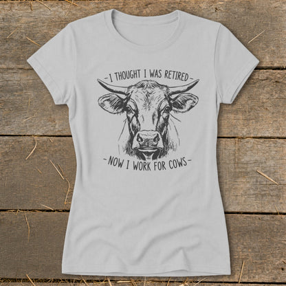 Light gray t-shirt with a sketch of a cow and text "I thought I was retired - Now I work for cows".