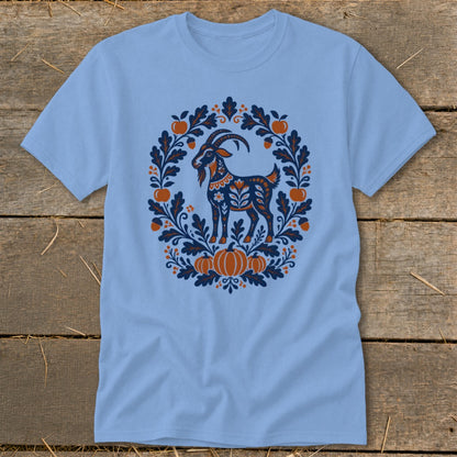 Light blue short-sleeve t-shirt featuring a blue and orange folk art goat surrounded by autumn foliage and pumpkins.