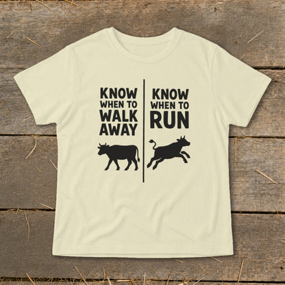 Cream t-shirt with black text and cow graphics reading "Know when to walk away" and "Know when to run".