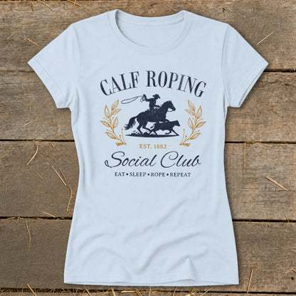 Light blue t-shirt with Calf Roping Social Club graphic and rodeo imagery.