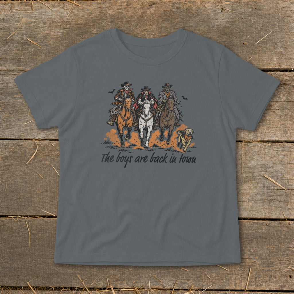 T-shirt graphic of three skeleton cowboys and a dog on horses with text "The boys are back in town."