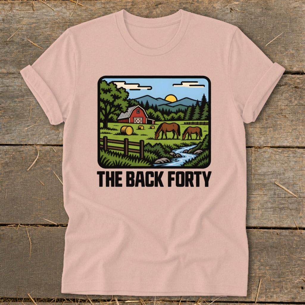 Dusty pink t-shirt featuring a rustic landscape graphic with horses, a red barn, and the text The Back Forty.