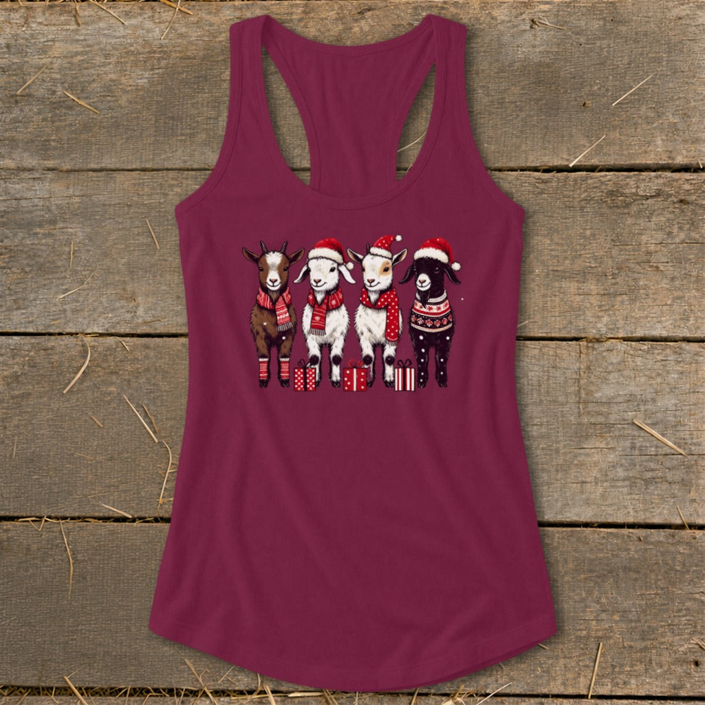 Four goats wearing Santa hats and scarves stand with gifts.