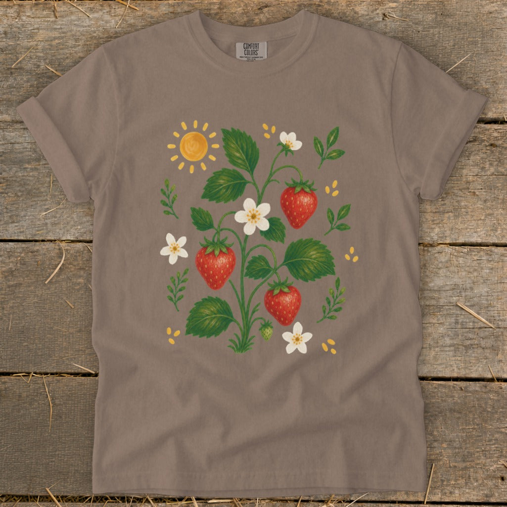 T-shirt with a watercolor illustration of a strawberry plant, sun, and flowers.