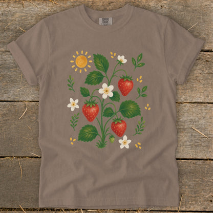 T-shirt with a watercolor illustration of a strawberry plant, sun, and flowers.
