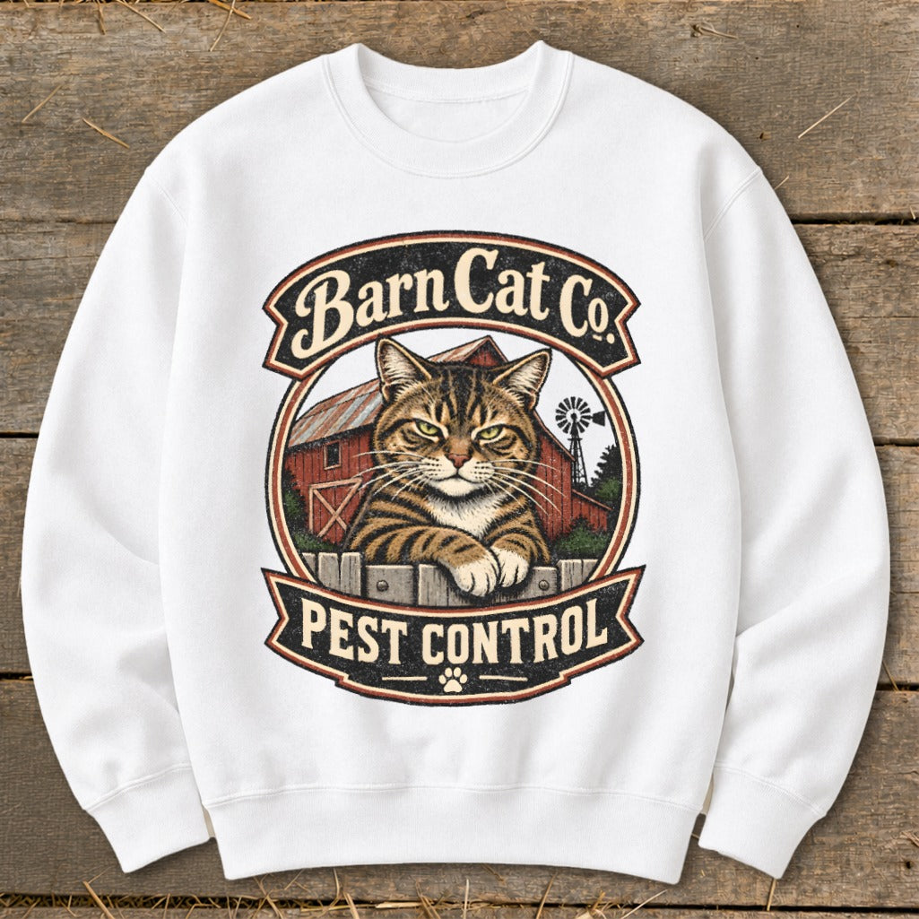 White crewneck sweatshirt featuring a graphic of a tabby cat resting on a fence in front of a red barn with text reading Barn Cat Co. Pest Control.