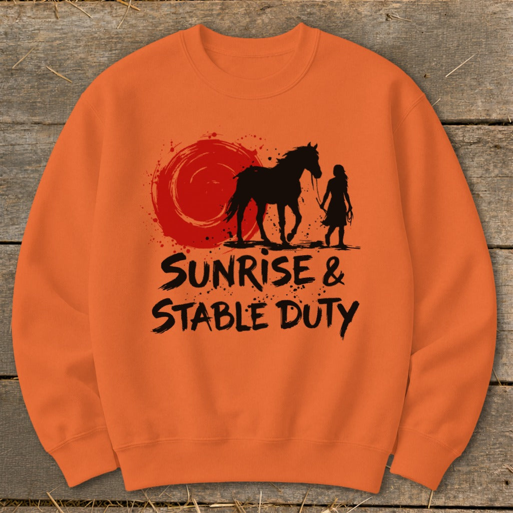 Orange sweatshirt with a graphic of a horse, person, and sunrise, reading "Sunrise & Stable Duty".