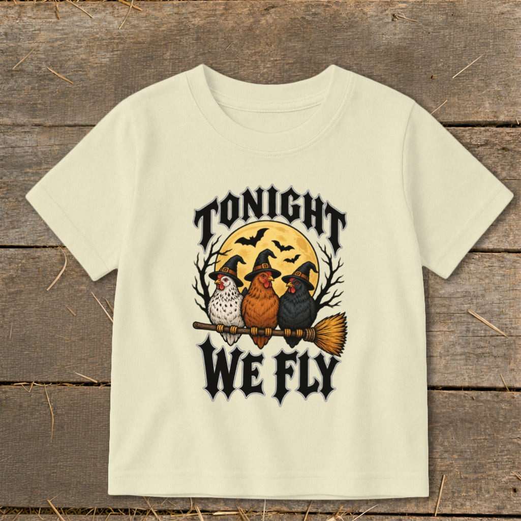 Three chickens in witch hats fly on a broomstick with text "TONIGHT WE FLY".