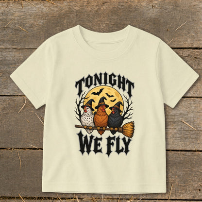 Three chickens in witch hats fly on a broomstick with text "TONIGHT WE FLY".