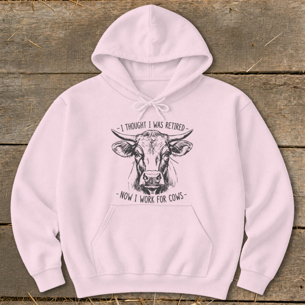 Pink hoodie with sketch of a cow and text "I thought I was retired - Now I work for cows".