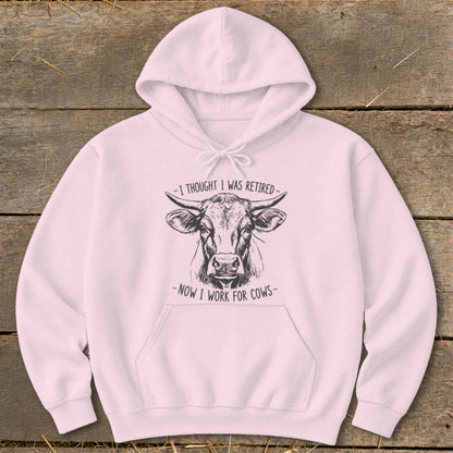 Pink hoodie with sketch of a cow and text "I thought I was retired - Now I work for cows".