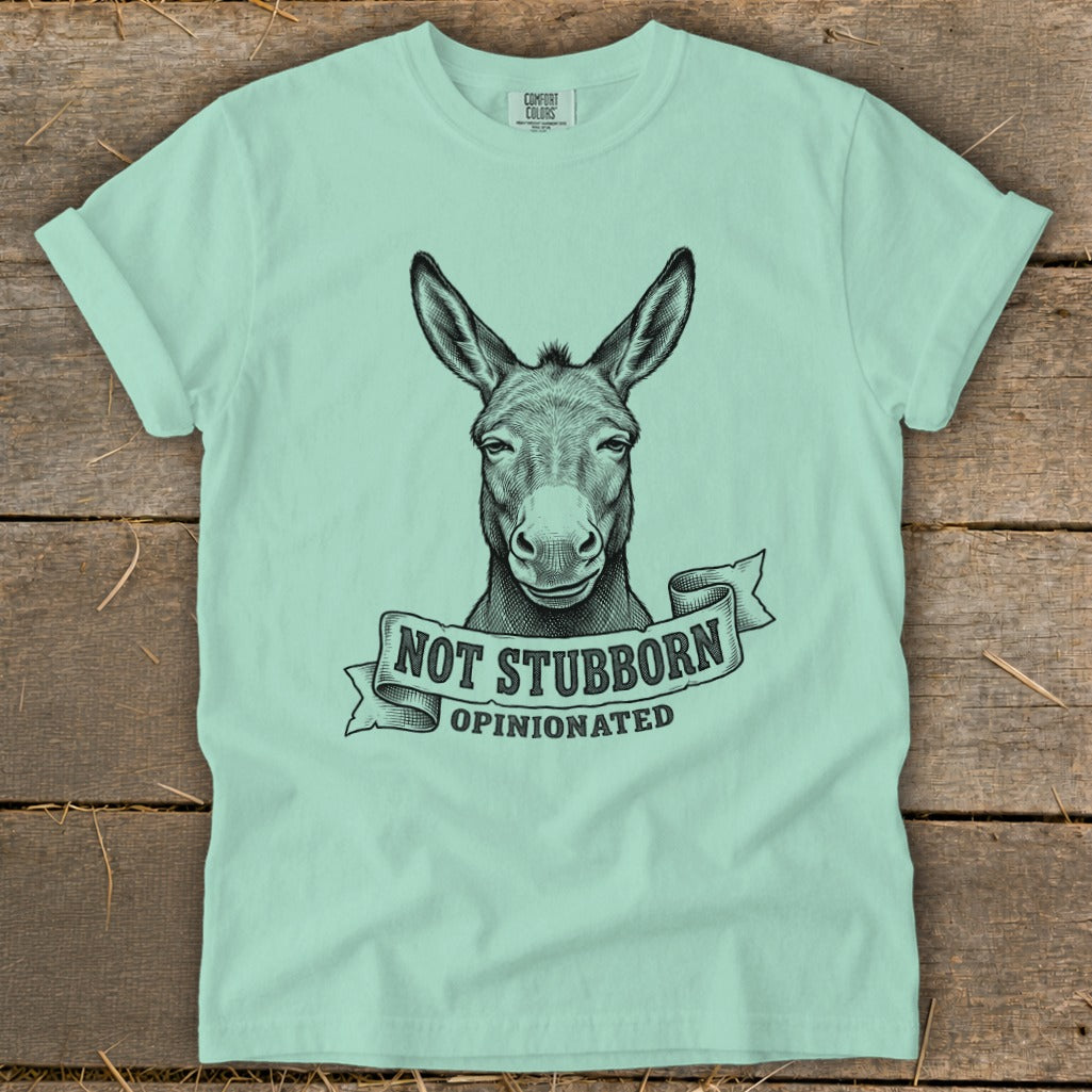 Mint t-shirt with black ink drawing of a donkey's head and "NOT STUBBORN OPINIONATED" text.