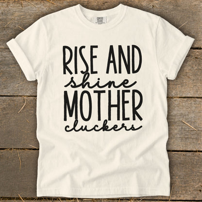 Cream t-shirt with black text "Rise and shine mother cluckers"