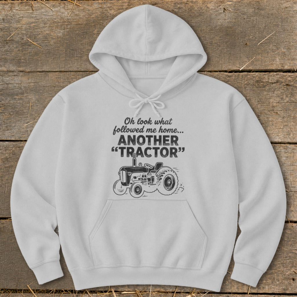 White hoodie with text "Oh look what followed me home... ANOTHER 'TRACTOR'" and tractor graphic.