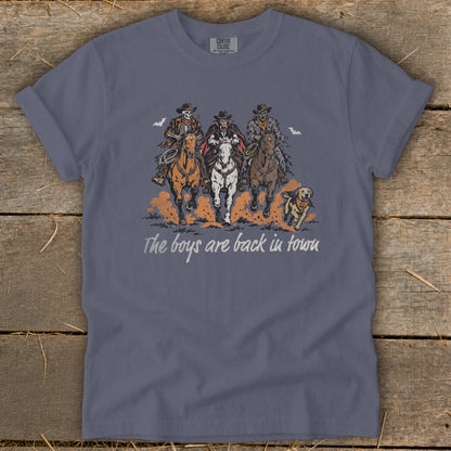 Skeleton, vampire, and zombie cowboys ride horses with a dog, text reads "The boys are back in town."