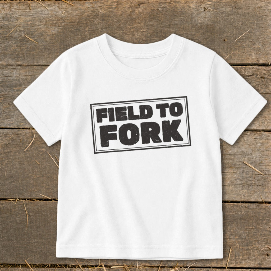 A white short-sleeved t-shirt featuring the black stamped text "FIELD TO FORK" centered on the chest.