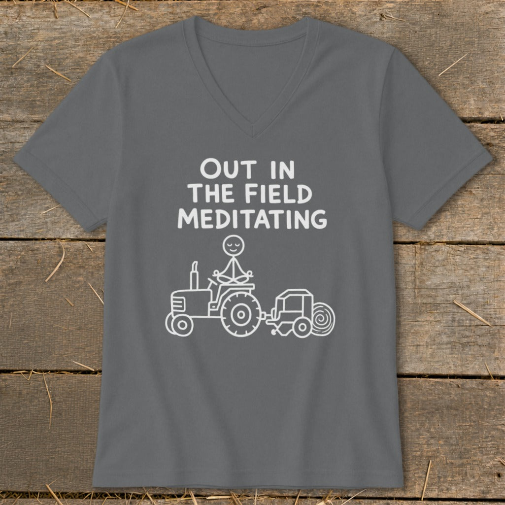 Gray t-shirt with white text "Out in the Field Meditating" and a drawing of a tractor.