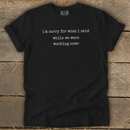 Black t-shirt with white text that says "i'm sorry for what i said while we were working cows".