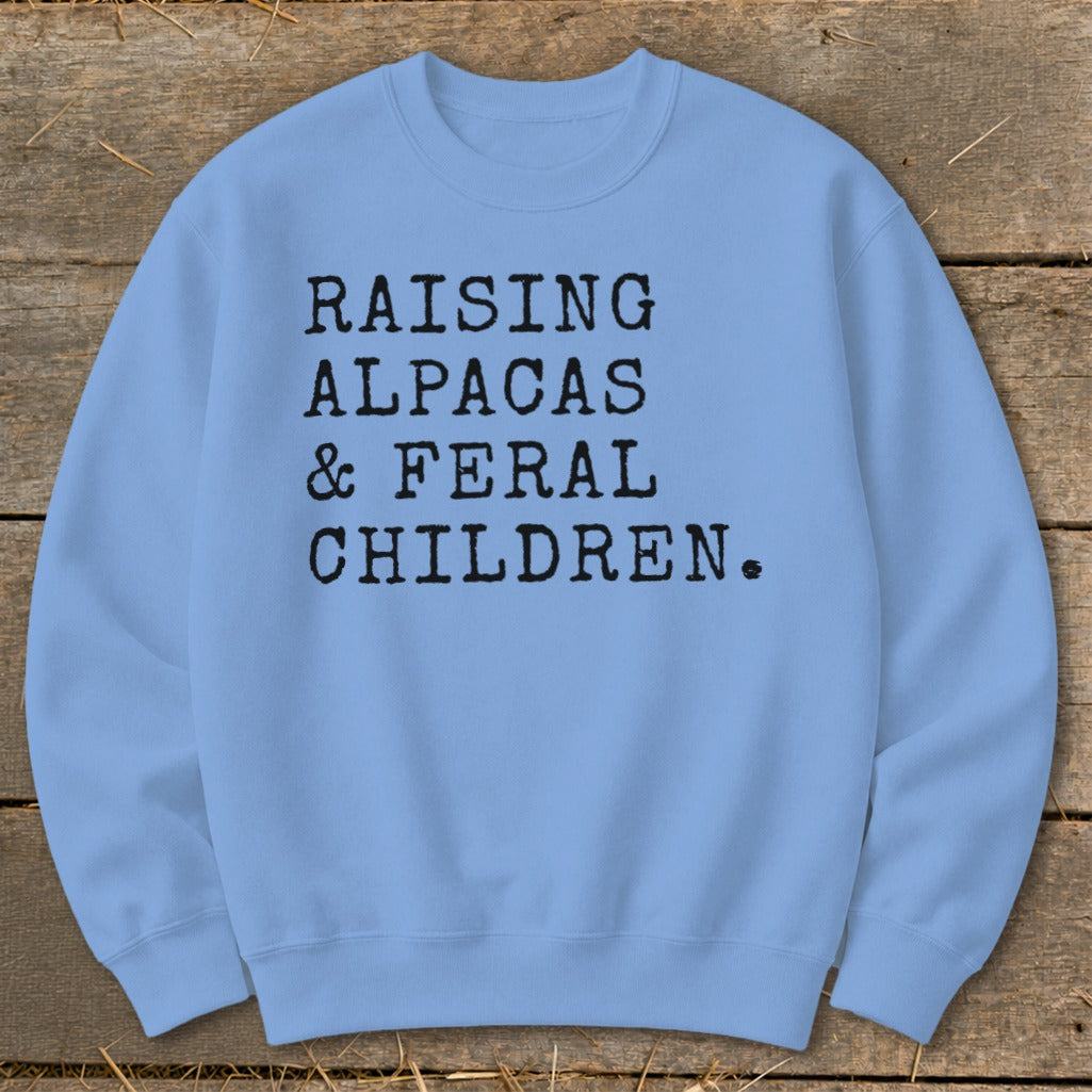 Light blue sweatshirt with "RAISING ALPACAS & FERAL CHILDREN." text.