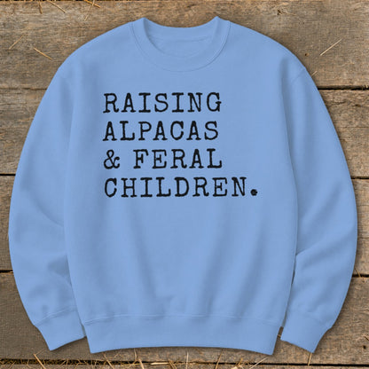 Light blue sweatshirt with "RAISING ALPACAS & FERAL CHILDREN." text.
