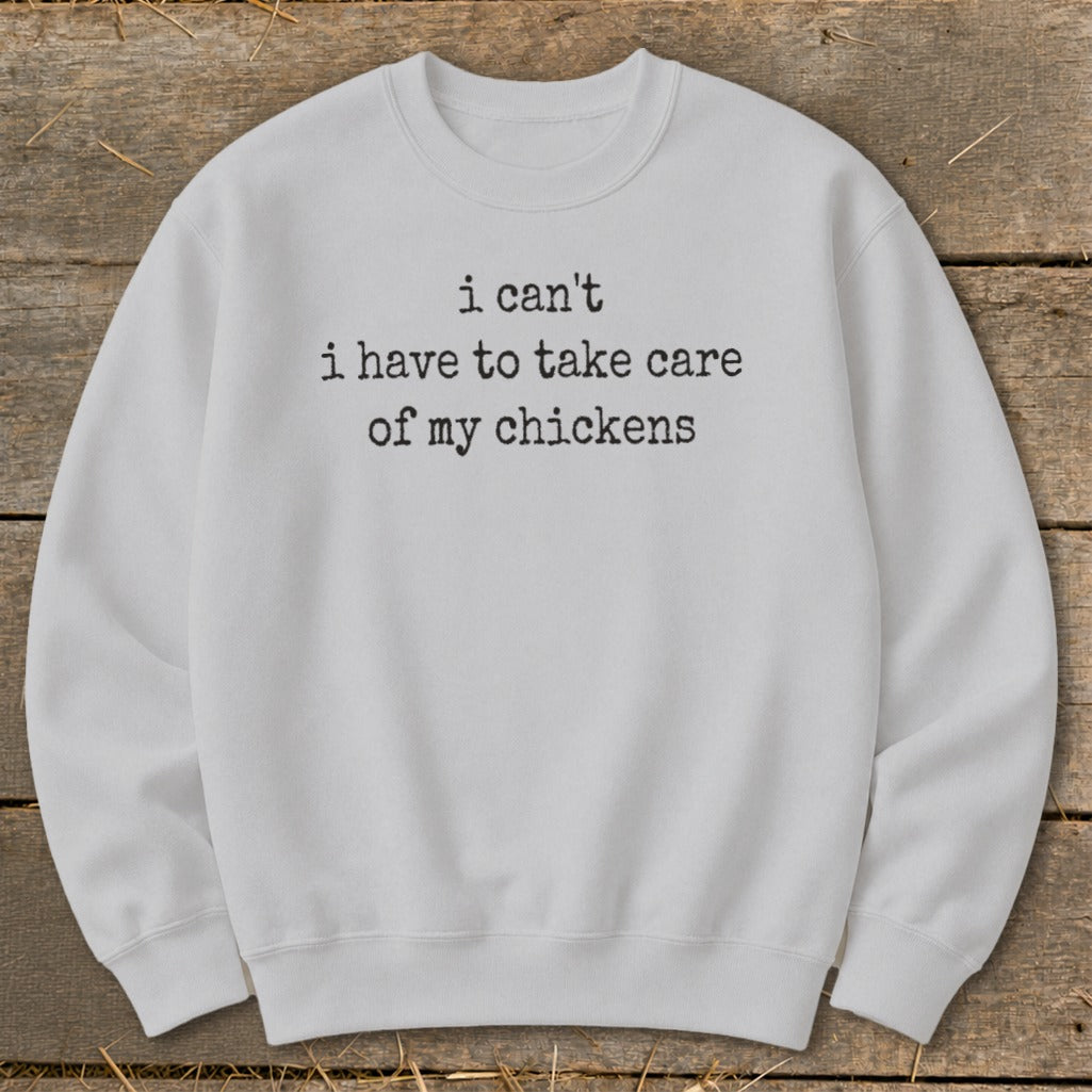 Light grey sweatshirt with black text: "i can't i have to take care of my chickens."