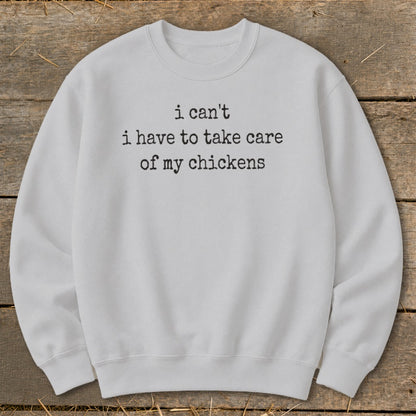 Light grey sweatshirt with black text: "i can't i have to take care of my chickens."